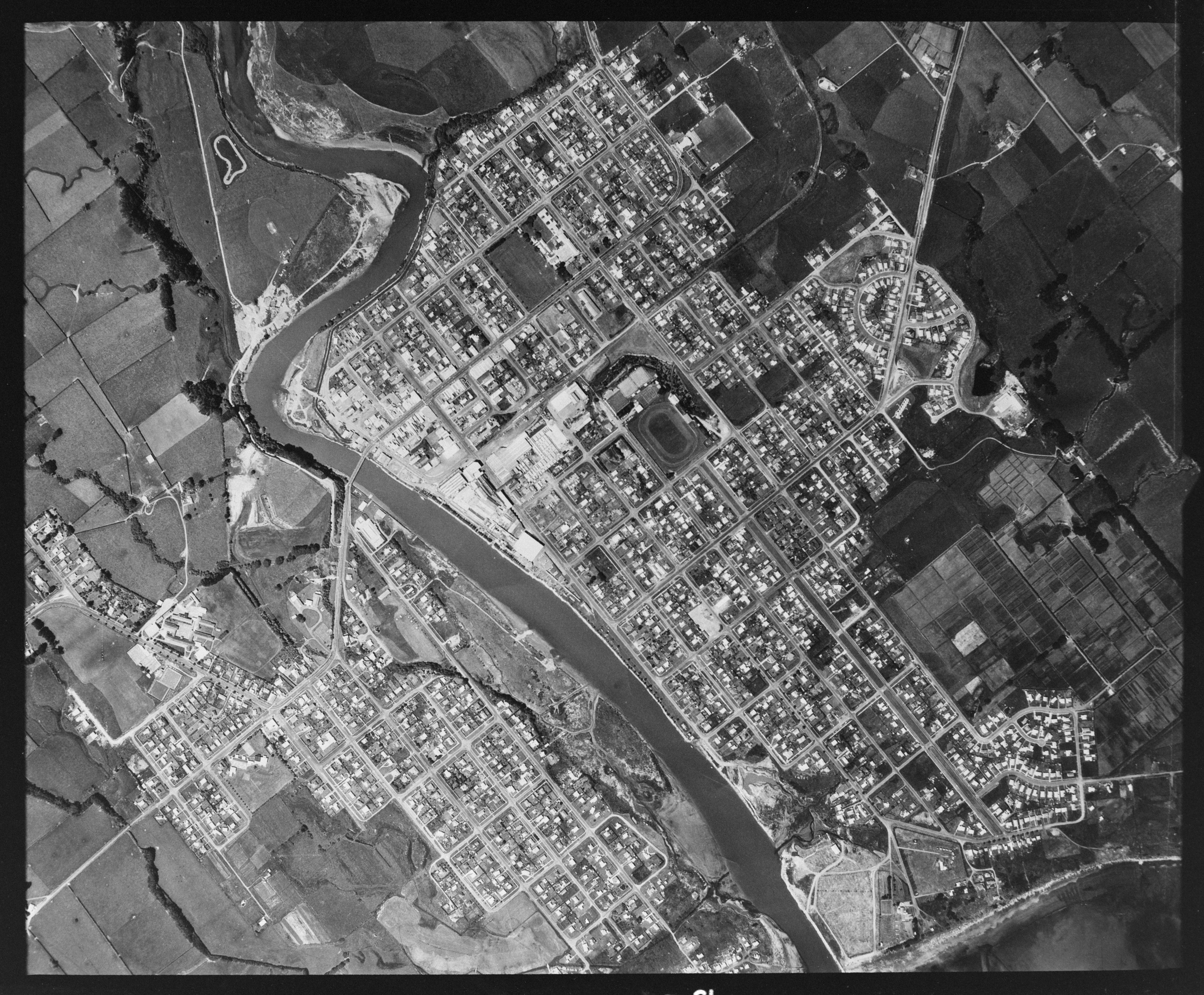 Aerial photograph of Waitara showing Memorial Place bordering Pukekohe Domain (20 December 1973). Bernard Woods Studio. Collection of Puke Ariki (WD.021516).