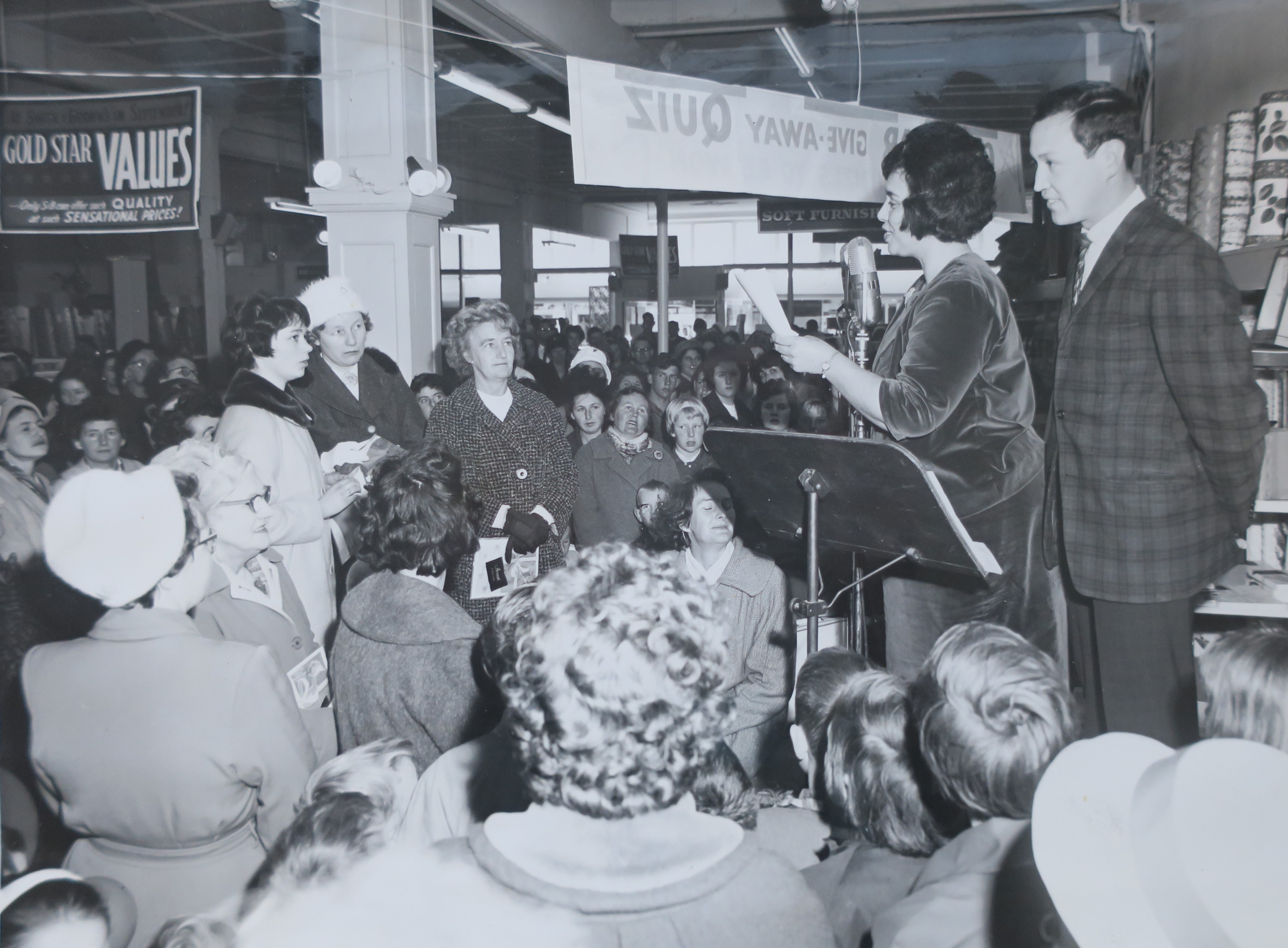 Marama and fellow Radio Taranaki announcer Eugene Fraser presenting a quiz show at a department store in New Plymouth (1964). Unknown photographer. Collection of Puke Ariki (ARC2003-215).